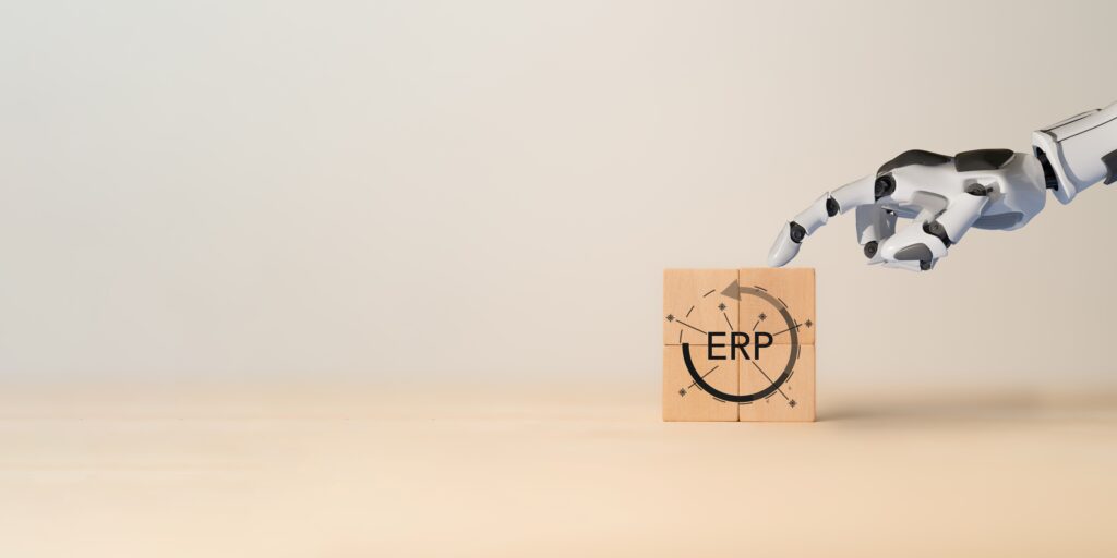 Ein roboterähnlicher Finger zeigt auf einen Holzblock mit der Aufschrift "ERP", was die Automatisierung und Integration von ERP-Systemen in Geschäftsprozesse symbolisiert.