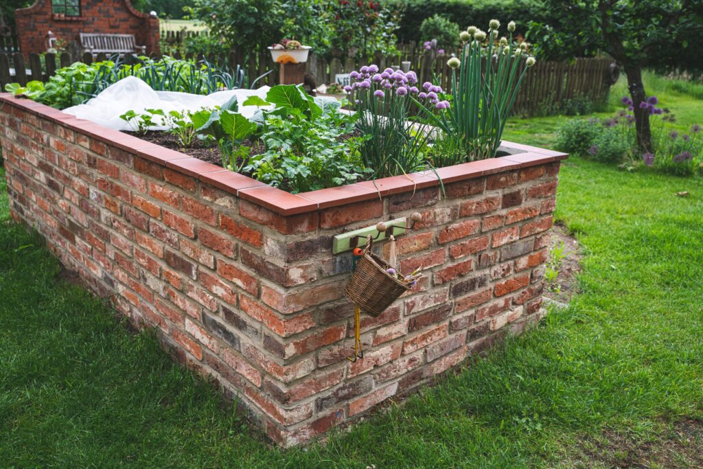 Ein Hochbeet mit nachhaltigen Materialien steht in einem Garten