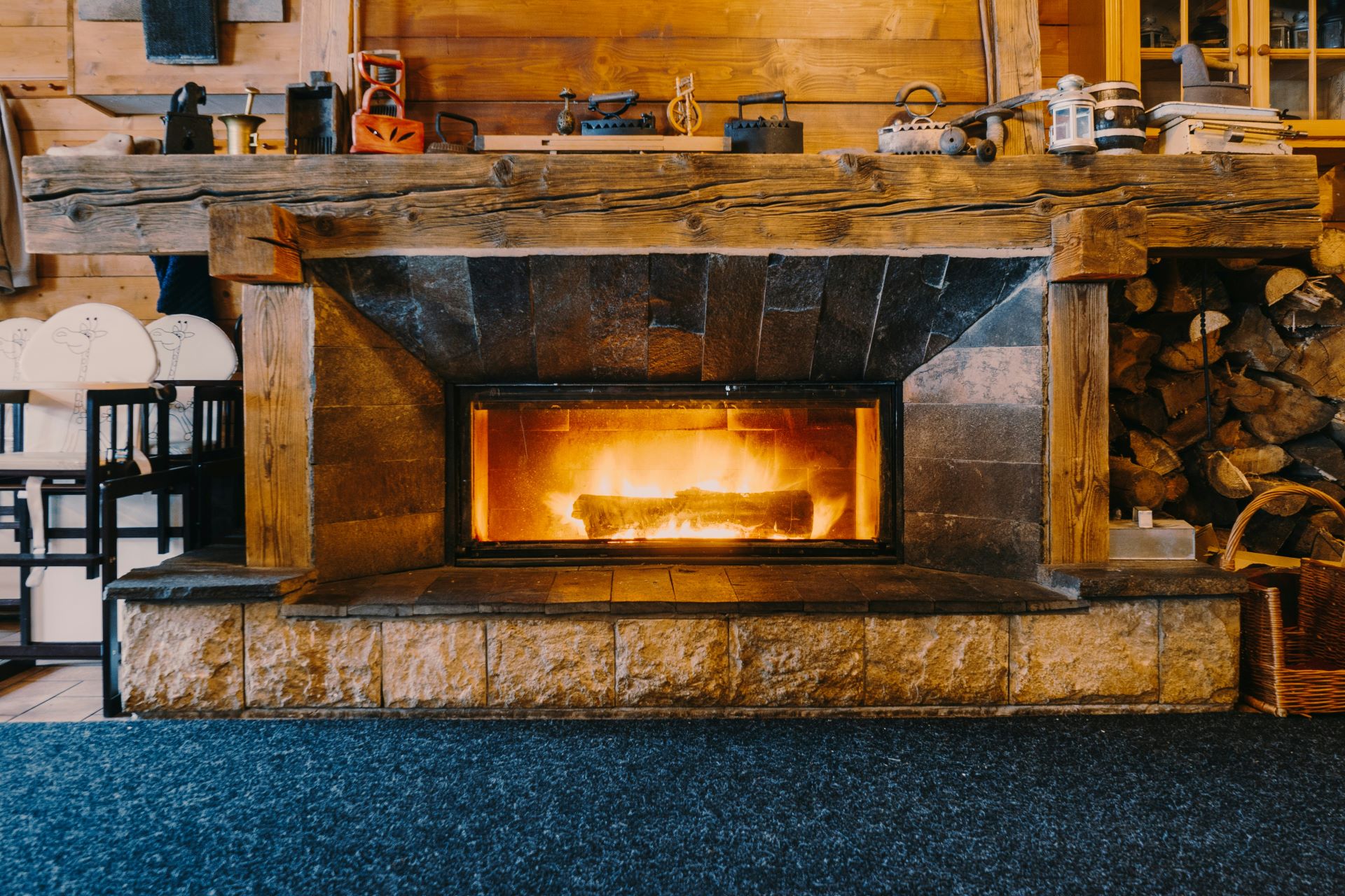 Rustikaler Kamin mit Holzverkleidung und brennendem Feuer in einem gemütlichen Raum – behagliche Kaminatmosphäre im Landhausstil.