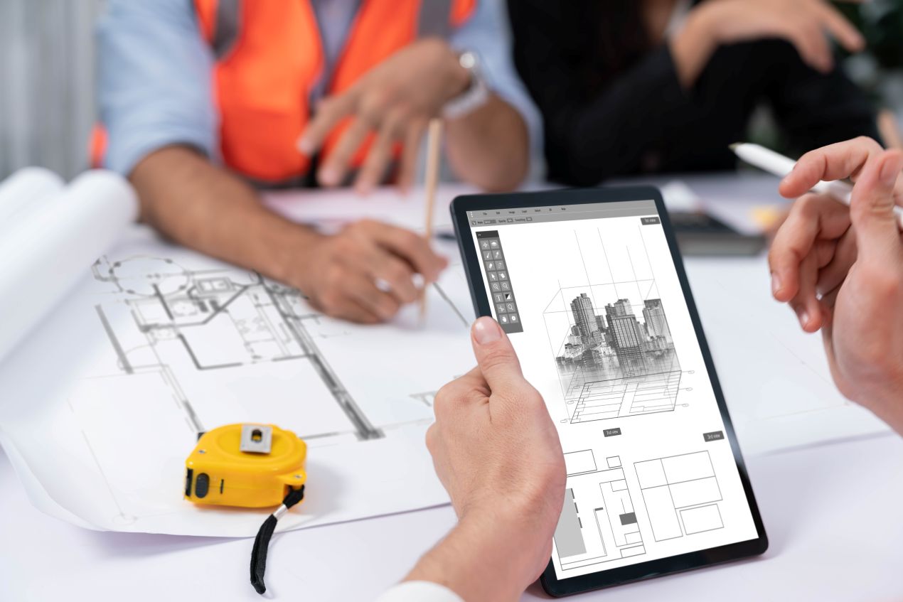 Ingenieur nutzt ein Tablet mit Bauplan-Visualisierung – Neigungssensoren optimieren die digitale Überwachung und Strukturkontrolle auf Baustellen.