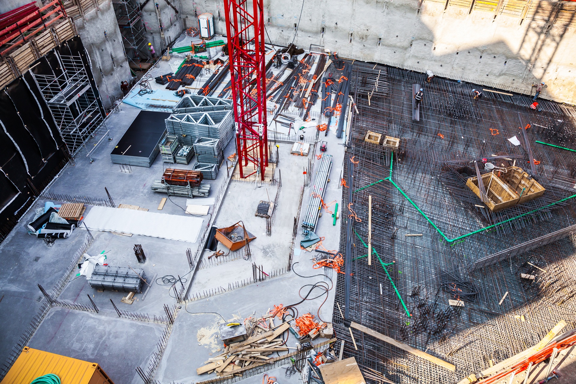 Draufsicht auf tiefe Baugrube mit Stahlbewehrung | Absperrgitter für Baustellen