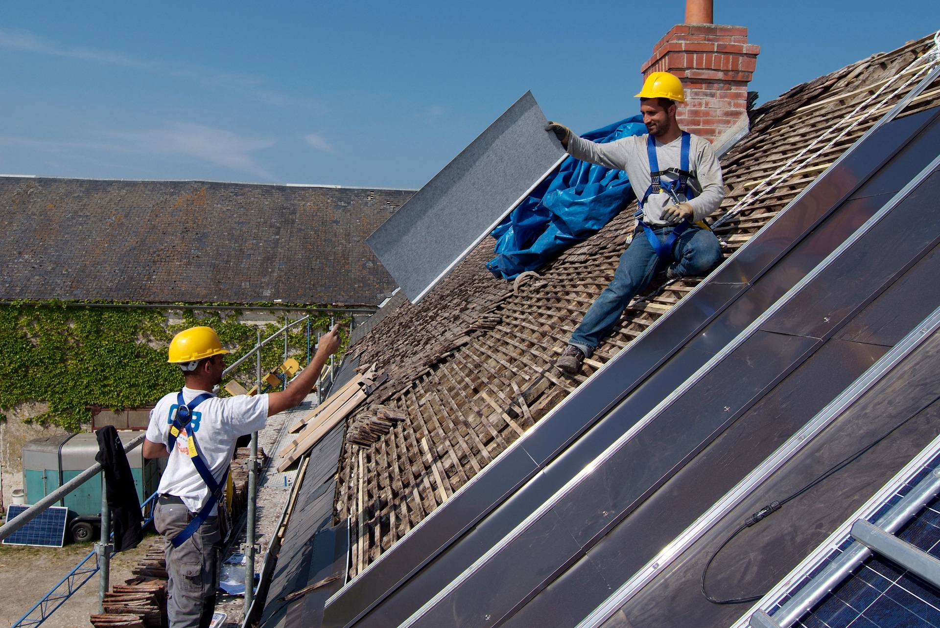 Dachdecker montieren Elemente auf hohem Steildach | Gerüstbanner